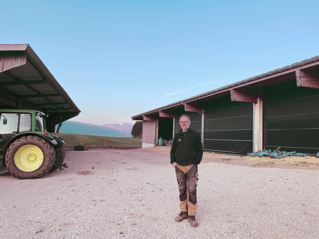 Stéphane Challandes pose devant son exploitation par journée de beau temps.